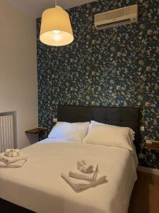 a bedroom with a large bed with a floral wallpaper at NOI Luxury rooms Colosseum in Rome