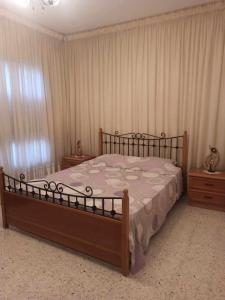 a bedroom with a large wooden bed with curtains at Appartement équipé et confortable à hammamet nord in Hammamet Nord +12 photos