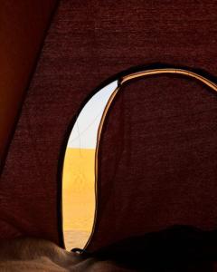 a window of a tent with a view of the desert at White desert camp in Bawiti