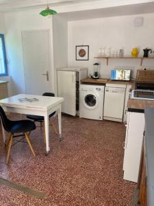 a kitchen with a white table and a washer and dryer at Casa Luna in Le Coudray-Macouard