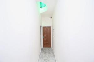a hallway with white walls and a brown door at Hotel O The Nest in Sohāna