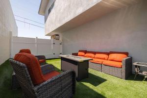 a patio with a couch and chairs on the grass at Central Spacious in San Diego