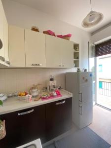 a kitchen with white cabinets and a white refrigerator at Casa Elisa in Santa Maria degli Angeli