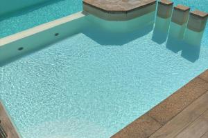 タナウネッラにあるAlba Vista Mare - Apartment mit Meerblick und Pool Budoni, Sardinienのベンチ付き水のプール +40枚の写真