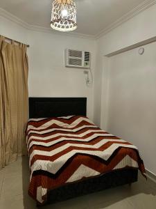 a bedroom with a bed with a striped blanket on it at El lapacho 2 in Santiago del Estero