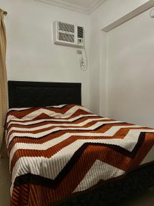 a bedroom with a bed with a striped blanket at El lapacho 2 in Santiago del Estero