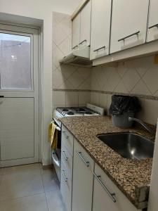 a small kitchen with a sink and a stove at El lapacho 2 in Santiago del Estero +4 photos