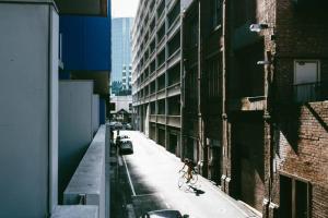 uma pessoa a andar de bicicleta numa rua ao lado de um edifício em Bent St Apartments em Adelaide