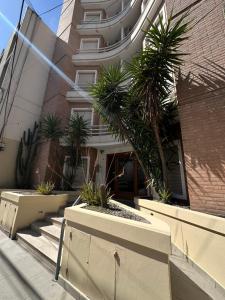 a building with palm trees in front of it at El lapacho 2 in Santiago del Estero