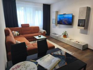 a living room with a couch and a tv at Apartmán M&K WEST in Poprad