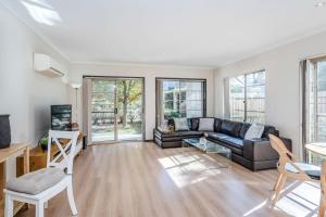 ein Wohnzimmer mit Sofa und Tisch in der Unterkunft Light filled 2 Brm Cityside in Turner + 1 Foto