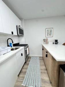 a kitchen with white cabinets and a sink and a rug at Yale Casa Baya in New Haven