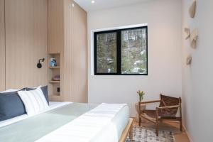 a bedroom with a bed and a window and a chair at Ghost Peak Chalet - Ski-In Access in Port Mann