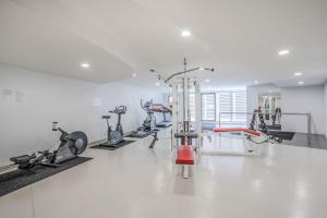 une salle de sport avec plusieurs tapis de course et vélos d'exercice dans l'établissement Citystyle 1Brm Phoenix in Braddon, à Braddon