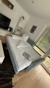 a bedroom with a white bed and a television at Ferienwohnung am Teufelsloch mit 2 Schlafzimmern und 2 Schlafcouchen a 1,4m in Altenahr