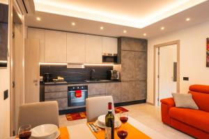 a living room with an orange couch and a kitchen at Quinta Stella in Tirano