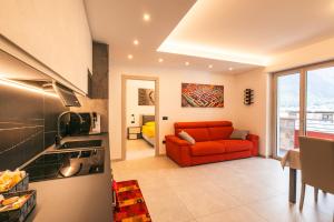 蒂拉诺Quinta Stella的客厅设有红色沙发,位于厨房内