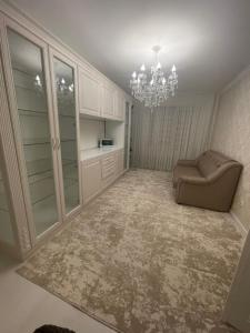 キシナウにあるModern Apartament Centru Rîșcaniの椅子とシャンデリアのあるリビングルーム