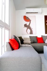 sala de estar con sofá gris y almohadas rojas en Spanish Sunrise 3BR Home with Pool Access, en San Miguel 13 fotos más