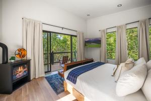 セバービルにあるHoneyscape Treehouse HotTub Intimate Getaway Firepitの大きなベッドと暖炉のある寝室