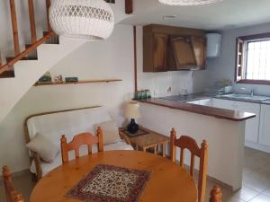 a kitchen with a table and chairs and a kitchen with a staircase at Casa Cambrils 500m playa AC in Cambrils