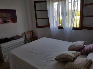 a bedroom with a bed with pillows and a window at Casa Cambrils 500m playa AC in Cambrils