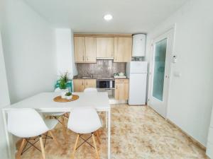 a kitchen with a white table and white appliances at CBN Apartments in Lloret de Mar