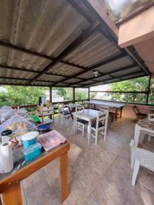 une chambre avec une table et quelques tables et chaises dans l'établissement Pousada Happy - 300m da Praia do Itaguaçú, à São Francisco do Sul