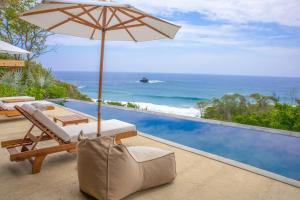 a patio with an umbrella and a swimming pool at Casa Miguana - Iguana in San Agustinillo +7 photos