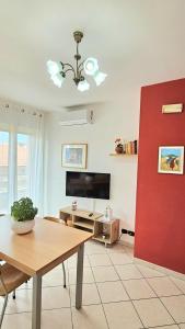 sala de estar con mesa y pared roja en Appartamento luminoso San Salvo, en San Salvo