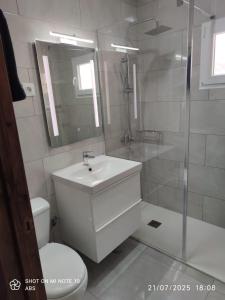 a white bathroom with a sink and a shower at Villa Mirador de la Loma in Pájara