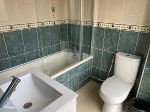 a bathroom with a toilet and a tub and a sink at Hôtel Résidence Châtillon in Paris