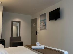 a hotel room with a bed and a flat screen tv at Hôtel Résidence Châtillon in Paris