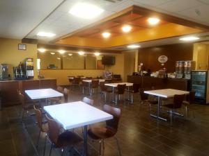 EvansvilleにあるSuper 8 by Wyndham Casper East/Evansvilleのテーブルと椅子のあるレストラン、バー