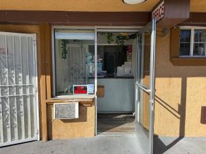 an entrance to a store with a sign in the door at Travel Inn Downtown LA in Los Angeles