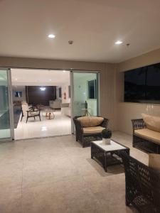 a living room with chairs and a couch and a table at Home Design Club in Sobral