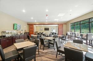 a dining room with tables and chairs and windows at Cobblestone Hotel & Suites - Bellefontaine in Bellefontaine