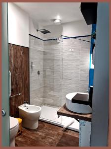 a bathroom with a tub and a toilet and a sink at Station Rooms in Modena