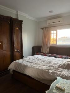 a bedroom with a bed and a dresser and a window at Poraa roof in Hurghada +4 photos