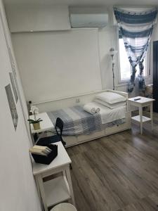 a small bedroom with a bed and two tables at Station Rooms in Modena
