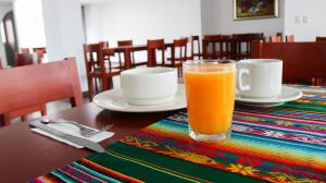 a glass of orange juice sitting on a table at Juan Sebastián Hotel in Pasto