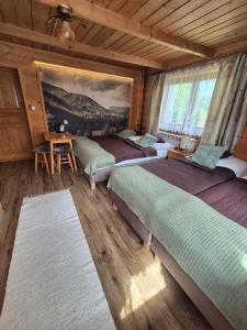 a bedroom with two beds and a table and a painting at U Parów - pokoje z jacuzzi i sauna, Białka Tatrzańska in Białka Tatrzańska +266 photos