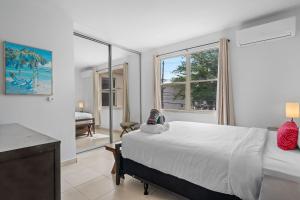 a bedroom with a bed and a desk and windows at Cacique Vacation Rental by Otium in San Juan +67 photos
