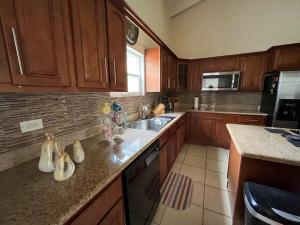 a kitchen with wooden cabinets and a counter top at Labor of Love in Christiansted +13 photos
