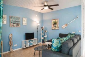 a living room with a couch and a ceiling fan at Matira Blue House in Bora Bora