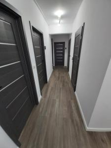 a hallway with black doors and wooden floors at 1140 Włościańska 5 - Tanie Pokoje w Apartamencie - samodzielne zameldowanie - self check in in Poznań +31 photos