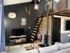a living room with a loft bed and a television at Pleasant townhouse with free parking in Saint-Cyprien