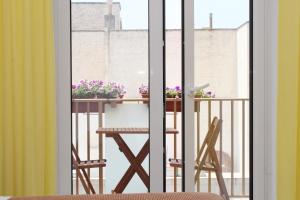 a table with two chairs and flowers on a balcony at Suitedelmare in Gallipoli