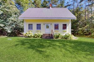 a small white house on a green lawn at Turner Hill Cottage in West Townshend