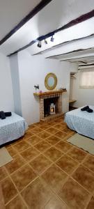 a living room with two beds and a fireplace at Casa Ariadna in Bocairent